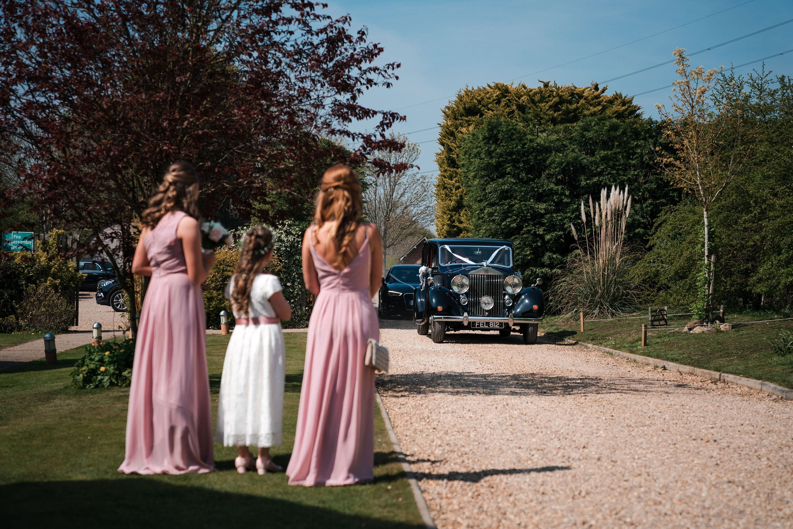 Carriage Hall wedding photograph of car driving into venue with bridesmaids waiting