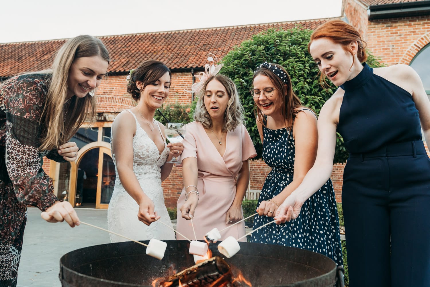 Bride toasting marshmallow's with her friends at Hazel Gap Barn
