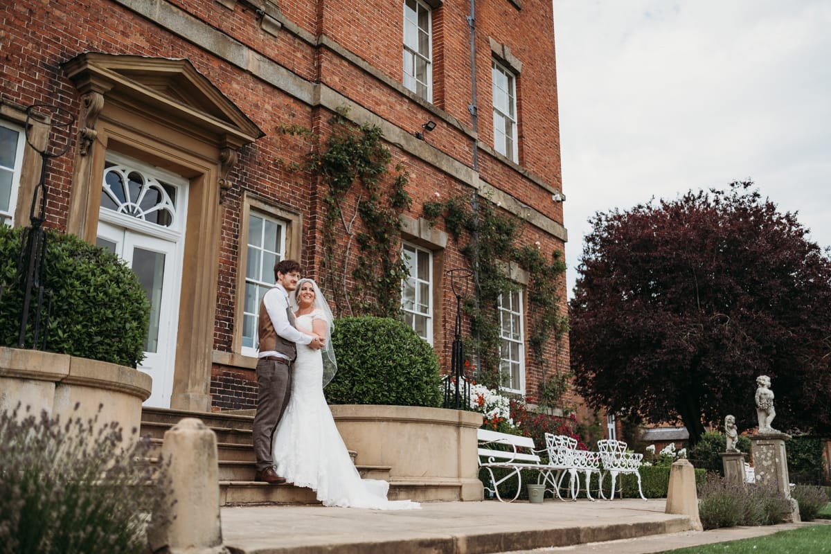 Bride & groom stood on steps at the rear of Norwood Park