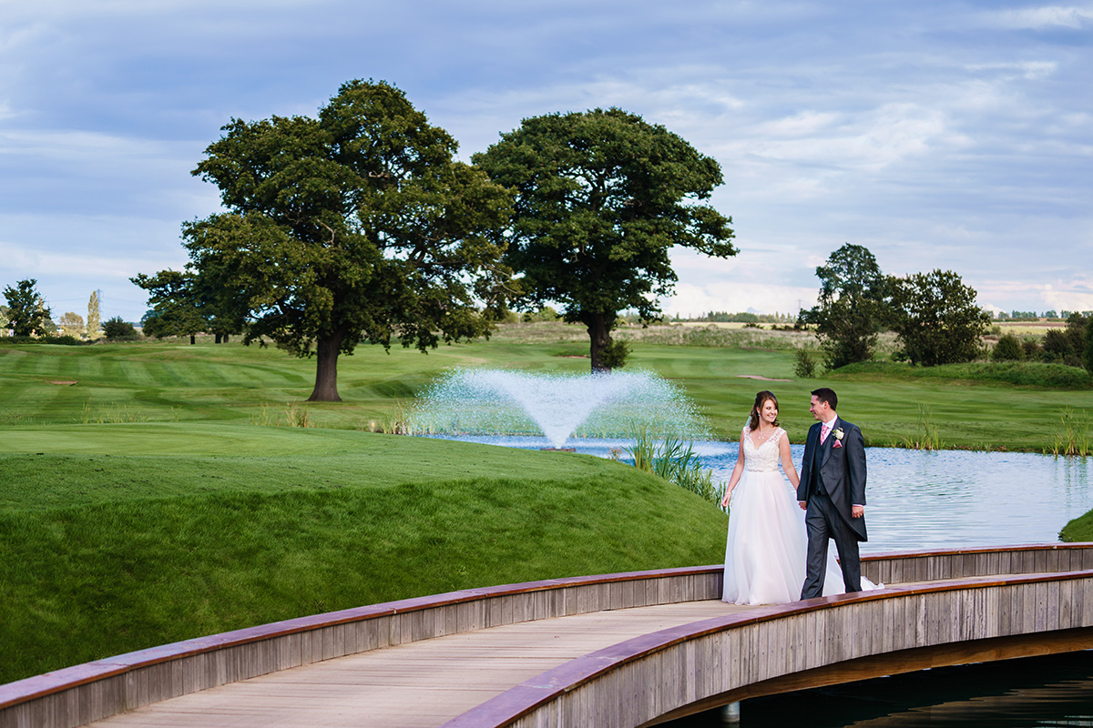 Bride & Groom walking across bridge at Nottinghamshire Golf & Country Club