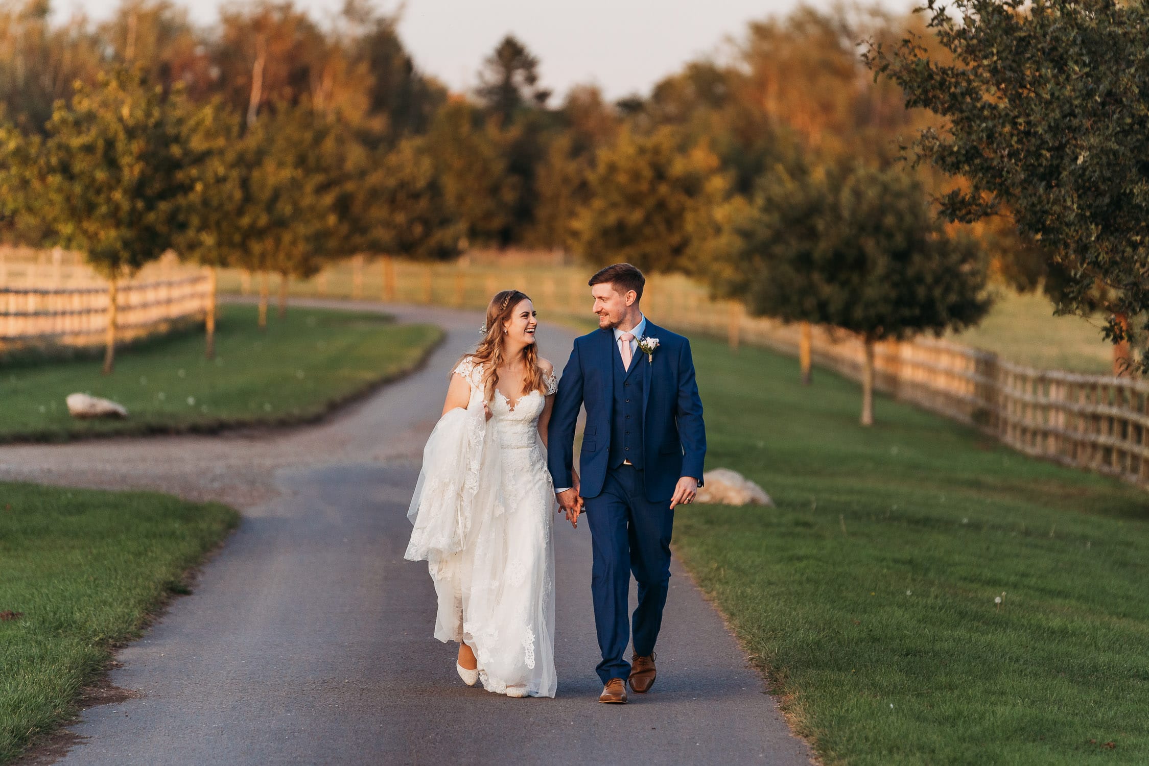 bride and groom walking back to venue after their photo session at Mythe Barn