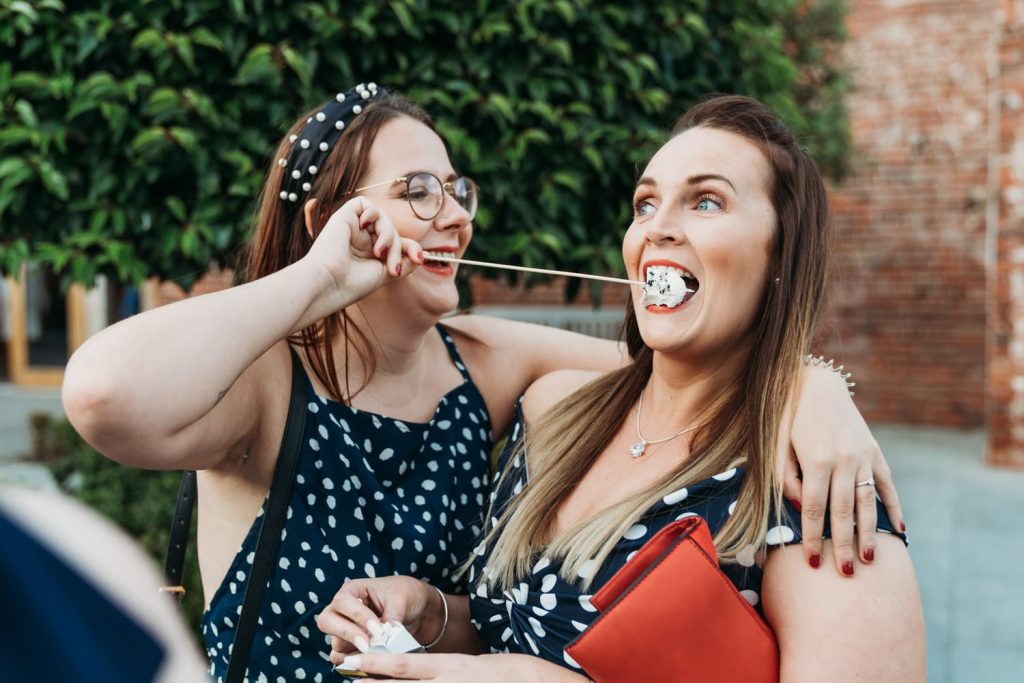 Wedding photo of guest at Hazel Gap Barn feeding a friend with a marshmallow which was toasted in the firepit